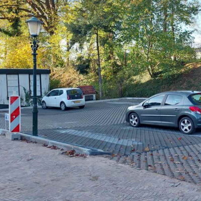 Ophef over straatstenen en haag bij parkeerplaatsen Muntwal